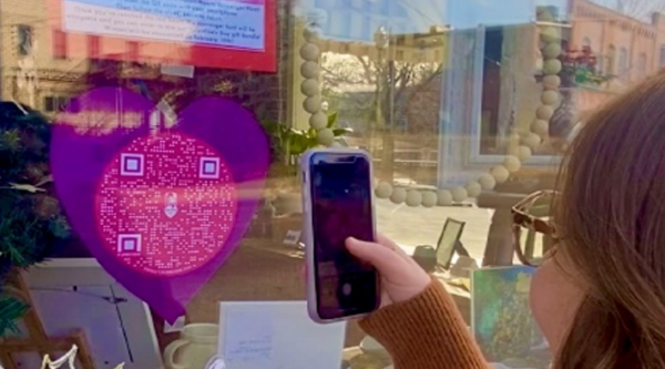 A woman scanning a QR code in a window